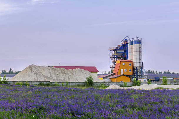 бетонний завод серед квіткових полів у сільській місцевості
 - Фото, зображення
