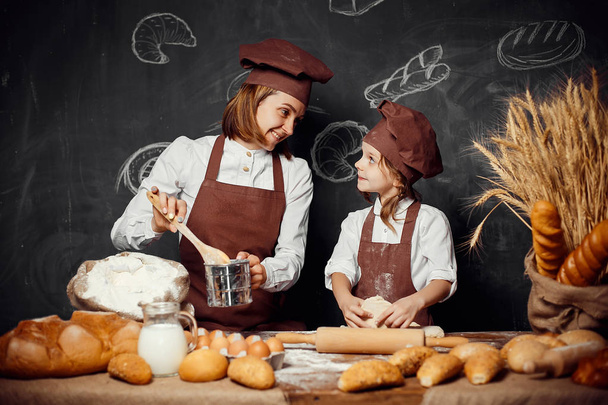 Woman and girl making pastries together - Fotó, kép