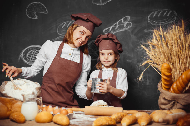 Woman and girl making pastries together - Photo, Image