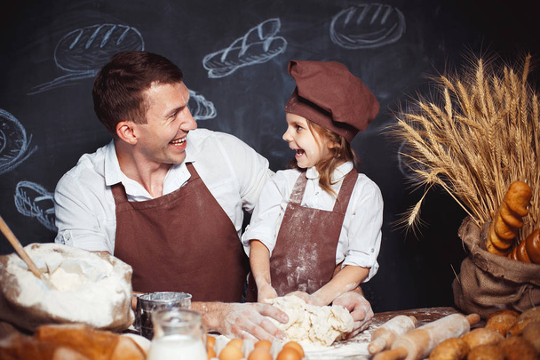 Laughing man with daughter making bread - Photo, Image