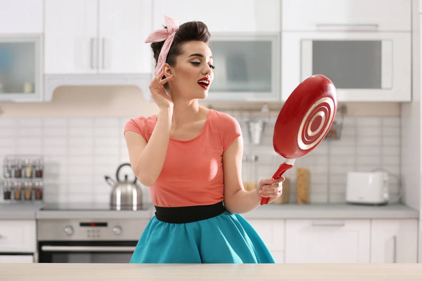 Funny young housewife with frying pan in kitchen - Foto, Bild