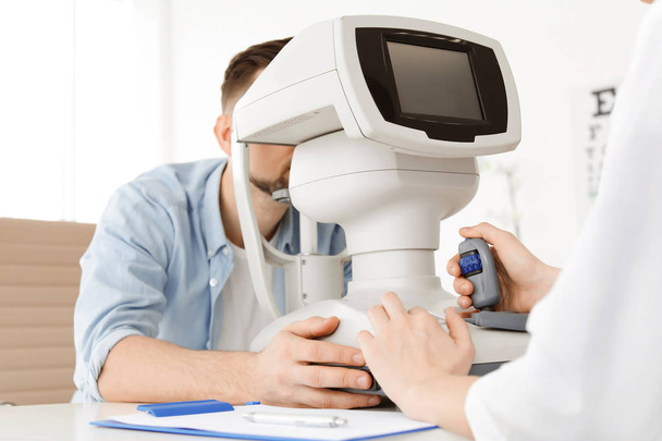 Ophthalmologist examining patient in clinic - Фото, зображення