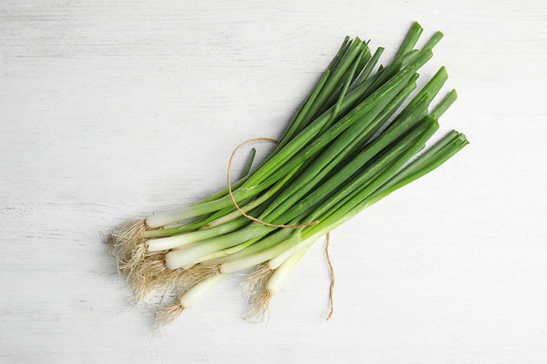Fresh green onion on wooden table, top view - Photo, image
