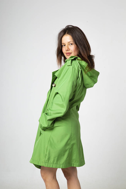 joven bonita mujer con piel de aceite verde con capucha y botas rojas
  - Foto, imagen