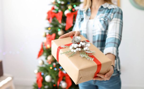 Young woman with Christmas gift at home - Photo, image