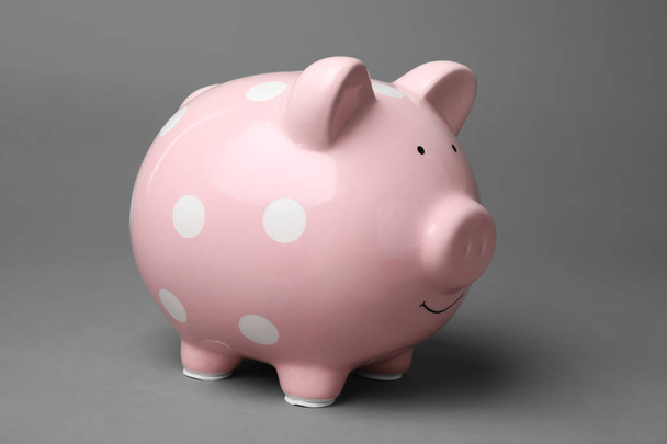 Cute pink piggy bank on gray background - Foto, Bild