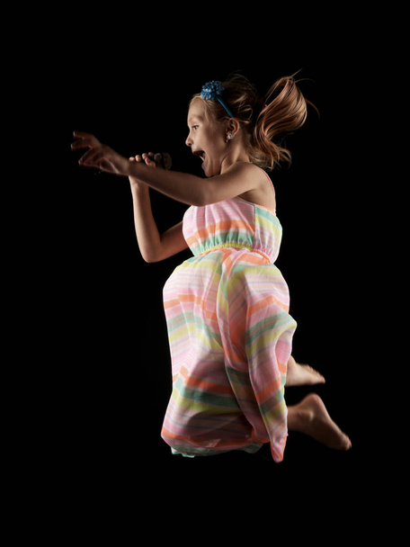 little girl performing with microphone in studio - Foto, Imagen
