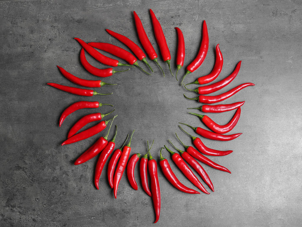 Flat lay composition with chili peppers on grey background - Fotografie, Obrázek