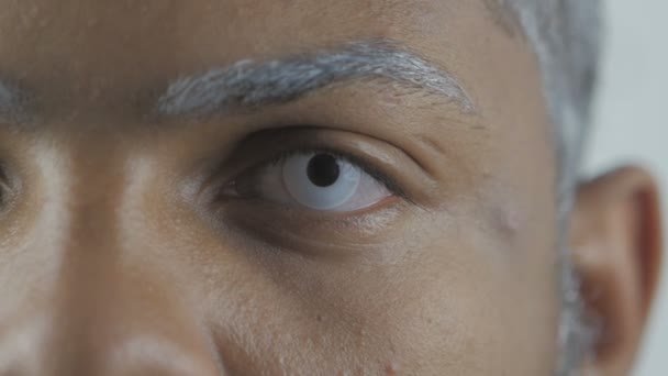 Close Up of Blinking Um olho de homem afro-americano com lentes de olhos brancos
 - Filmagem, Vídeo