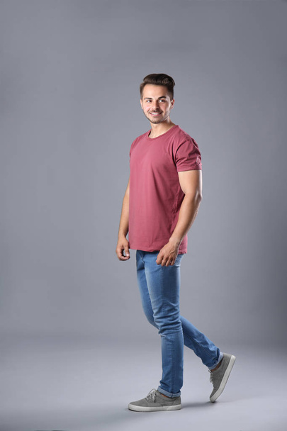 Young man in stylish jeans on grey background - Photo, image
