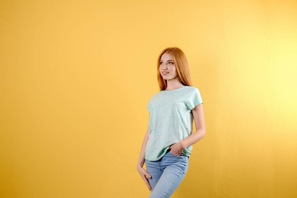 Young woman in stylish jeans on color background - Photo, Image