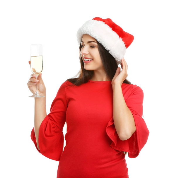 Young beautiful woman in Santa hat holding glass of champagne on white background. Christmas celebration - Foto, imagen