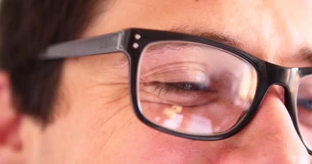 attraktiver junger Mann mit Smartphone beim Chat-Tippen, reflektierende Augen in Brille in Großaufnahme. - Filmmaterial, Video