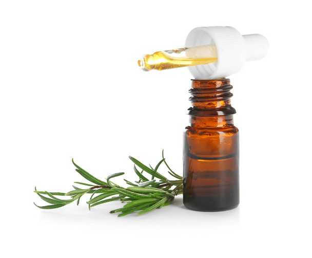 Small bottle with rosemary oil and fresh twig on white background - Φωτογραφία, εικόνα