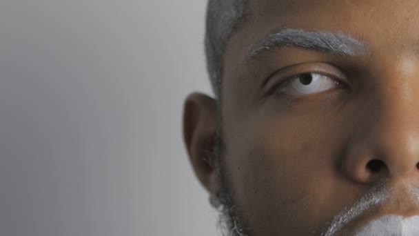 Retrato de metade do rosto do homem afro-americano demoníaco com olhos e lábios brancos
 - Filmagem, Vídeo