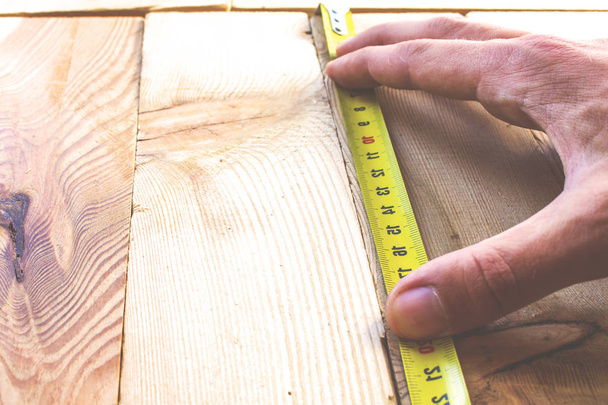 Measure with a tape measure on a wooden board, retro toned - Φωτογραφία, εικόνα