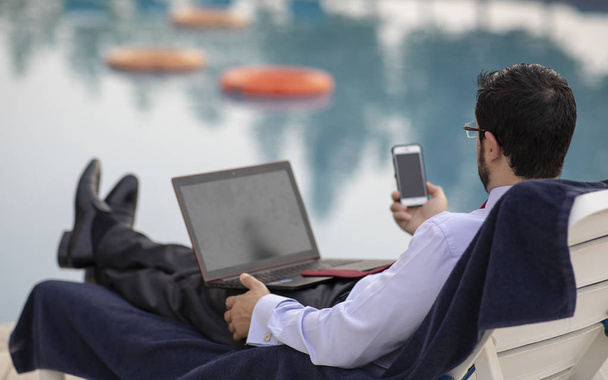 中年のアラブ人、プールで彼の夏の休暇中に作業 - 写真・画像