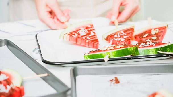 Step by step. Watermelon wedges garnished with chocolate and sea salt  on the stick on metal serving tray. - Photo, Image
