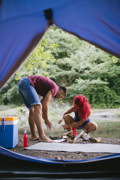 Young happy couple enjoying camping and hiking in wild nature. Selective focus. - Photo, Image