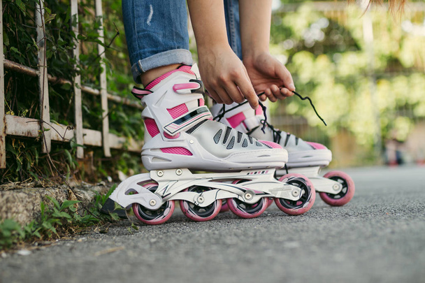 Urban scene of girl with putting on her roller skates. - Фото, зображення