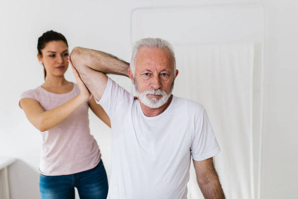 Senior man exercises in center for chiropractic. - Foto, Bild