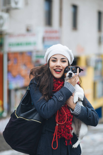 Linda jovem morena desfrutando de rua da cidade ao ar livre, juntamente com seu lindo Jack Russell terrier
. - Foto, Imagem
