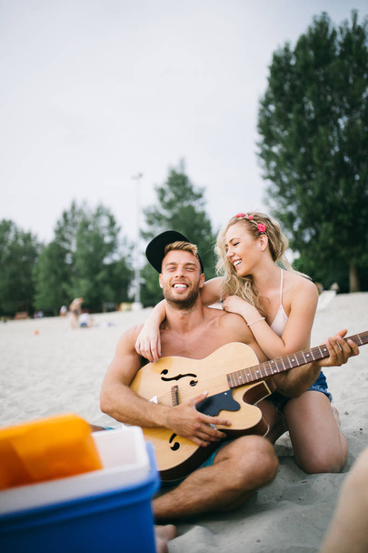 Joven pareja atractiva disfrutando en vacaciones en la playa y divirtiéndose
.  - Foto, Imagen