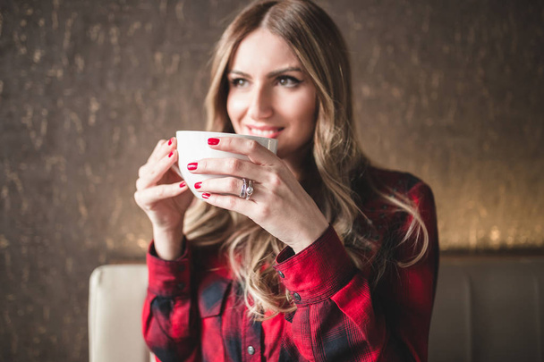 美しい若い女性カフェ レストランに座って、リラックスしてコーヒーを飲む.  - 写真・画像