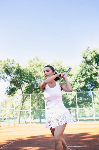 Portrait of beautiful young woman playing tennis. - Фото, изображение