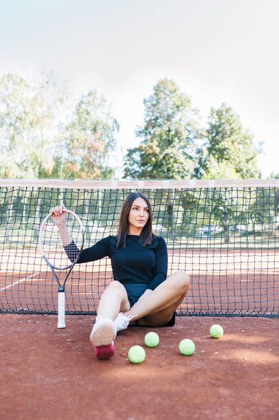 Piękna młoda kobieta relaksujący na kort po jej mecz tenisowy. - Zdjęcie, obraz