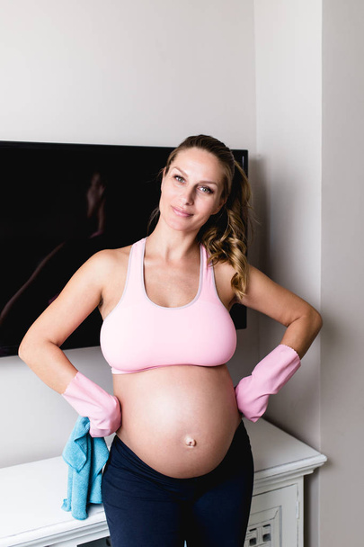 Young pregnant woman cleaning house with microfiber cloth. - Foto, Imagen