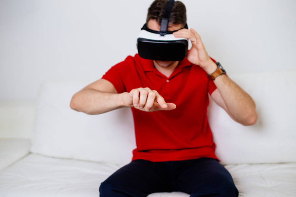 Giovane uomo che indossa occhiali di realtà virtuale e giocare al videogioco
 - Foto, immagini