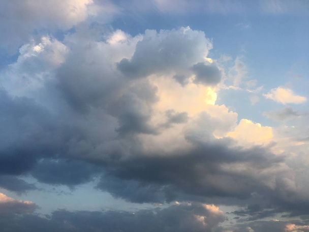 Prachtige wolken tegen de achtergrond van een blauwe hemel. Cloudscape hemel. Blauwe hemel met bewolkt weer, natuur wolk. Witte wolken, blauwe lucht en zon - Foto, afbeelding