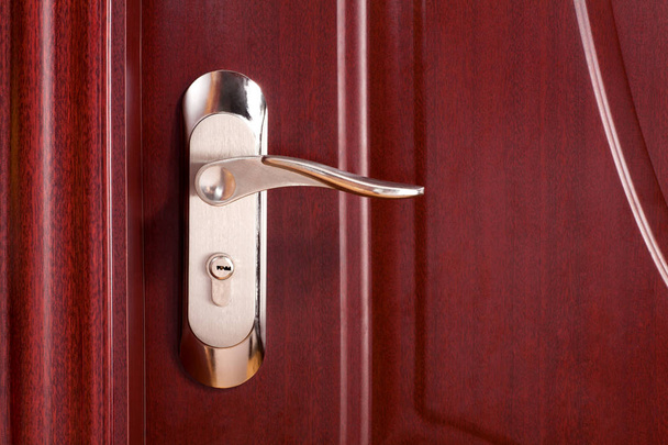 Maniglia porta esterna con serratura su porta in legno
 - Foto, immagini
