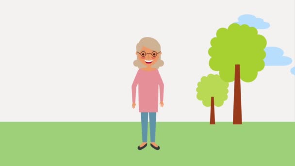 boldog idős nő a szemüveg a parkban - Felvétel, videó