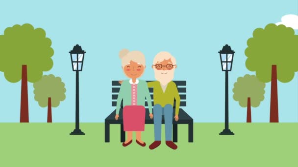 bejaarde echtpaar zittend op een bankje in het park - Video