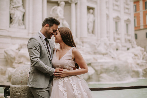 Just married bride and groom posing in front of Trevi Fountain (Fontana di Trevi), Rome, Italy - 写真・画像