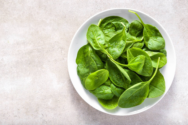 Green leaves of spinach on plate, healthy diet, vegan food concept - Valokuva, kuva