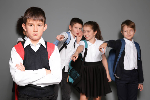 Children bullying their classmate on grey background - Photo, image