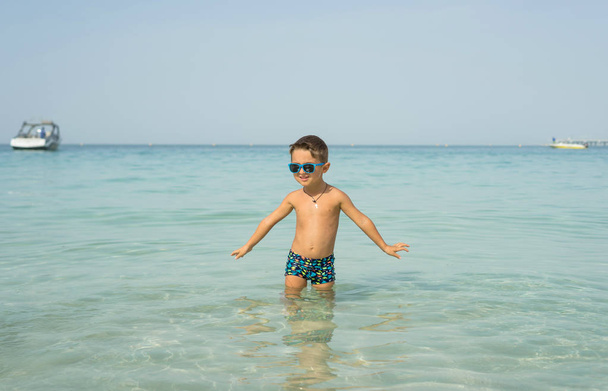 Retrato sorrindo menino brincando no mar, oceano. Emoções humanas positivas, sentimentos, alegria. Engraçado bonito criança fazendo férias e desfrutando de verão
. - Foto, Imagem