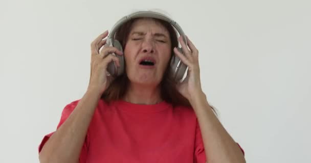 Gritando mulher adulta não gosta do que ouve em fones de ouvido
 - Filmagem, Vídeo