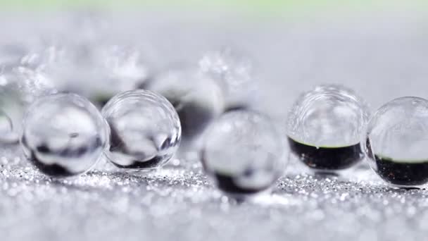Boules d'eau Crystal Gel sur rotation de texture pailletée argentée. Fermer les images macro
. - Séquence, vidéo