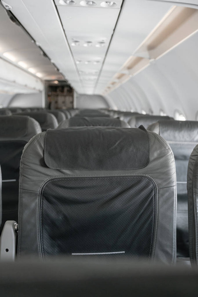 Empty airplane seats in the cabin. Modern Airplane seats in perspective. Transportation concept. Aircraft long-distance international flight - Photo, Image