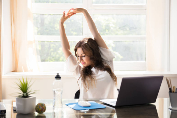 Happy Young Businesswoman Stretching Her Arms In Office - Fotografie, Obrázek