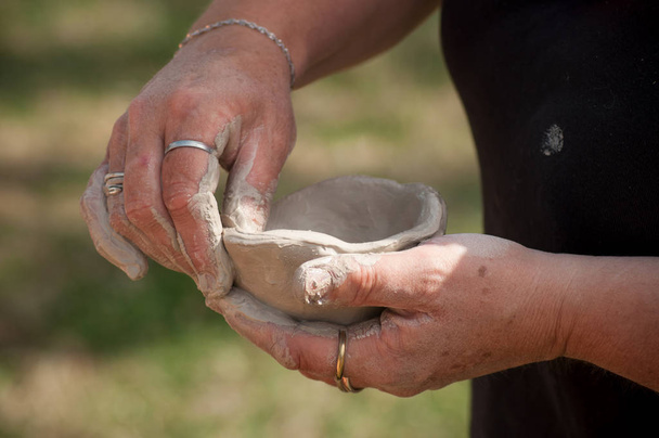 closeup of hands of old woman making clay pottery bowl in outdoor  - Φωτογραφία, εικόνα