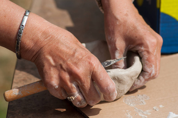 closeup of hands of old woman making clay pottery bowl in outdoor  - Фото, изображение