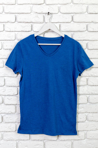 brick whitewashed wall with t-shirt on hanger - Fotoğraf, Görsel