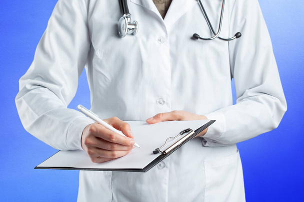 close up of medical doctor hands holding clipboard - Foto, afbeelding