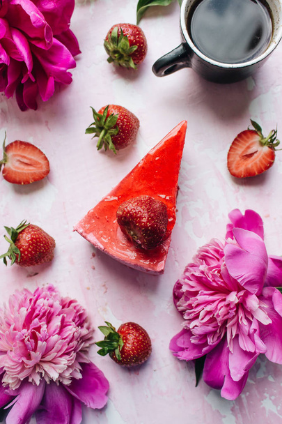  délicieux gâteau aux fraises et tasse à café, dessert sucré décoré de fleurs de pivoine rose
  - Photo, image