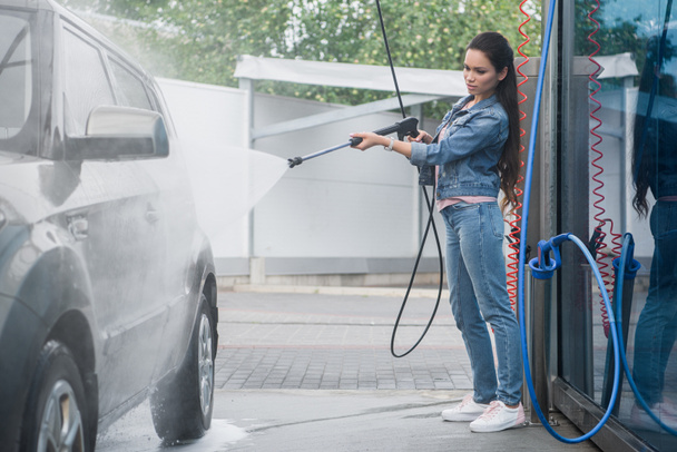 piękna kobieta, czyszczenie samochodu na myjni samochodowej strumieniem wody pod wysokim ciśnieniem - Zdjęcie, obraz